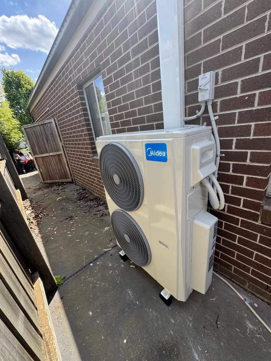 Midea multi-split outdoor air-conditioning unit installed beside a brick home in Victoria